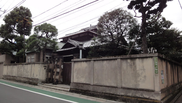 a traditional house behind a wall